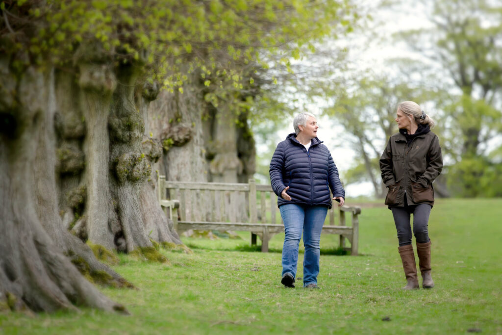 Eileen and client walking along a woodland path during a walk and talk therapy session in Stockprot"