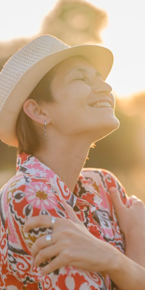 Woman standing quietly with eyes closed, a peaceful and reflective expression, soft natural light